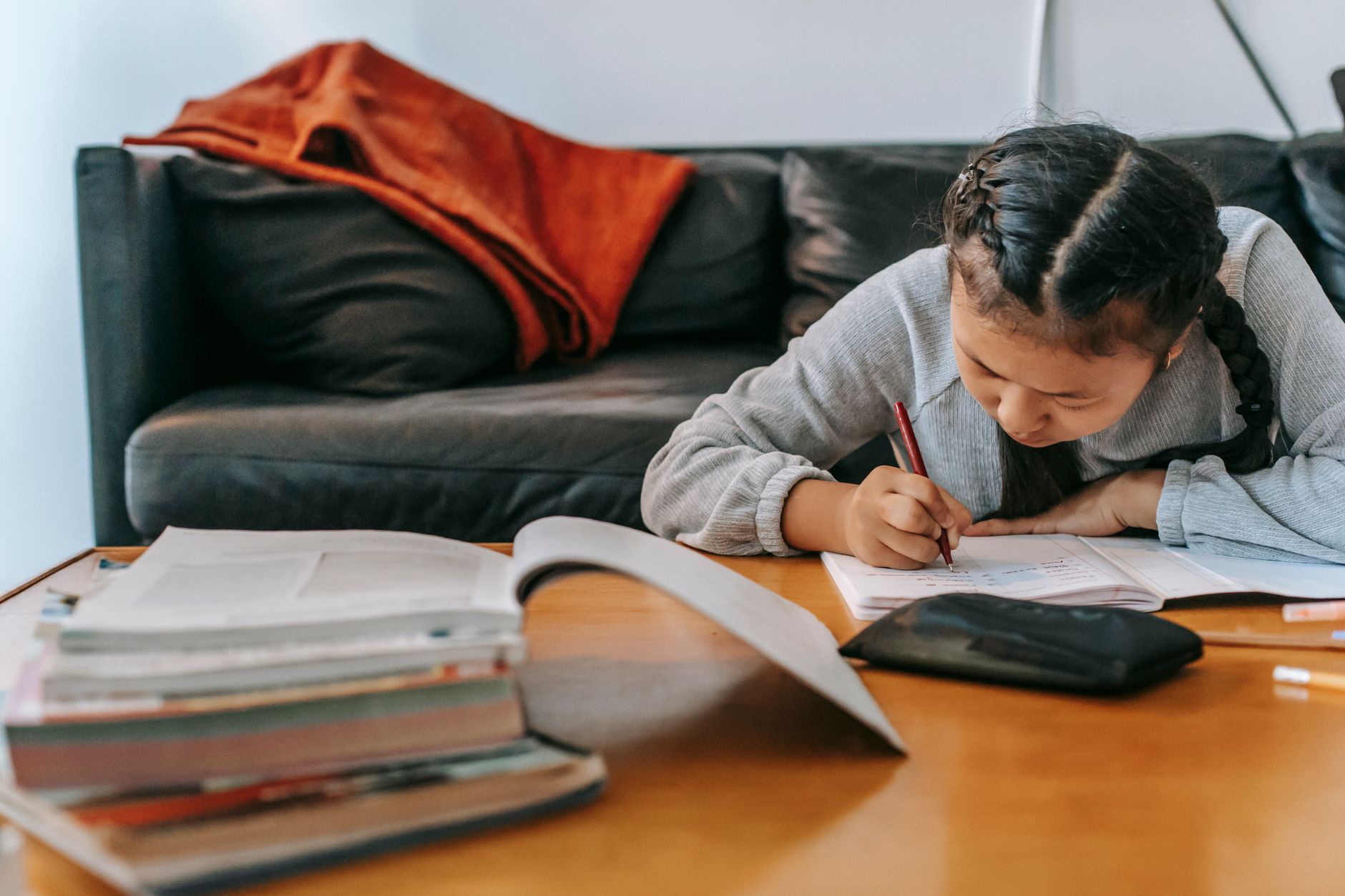 A child taking notes in a workbook at a desk