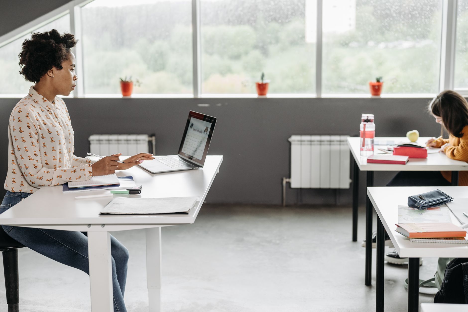 A teacher using a laptop at her desk